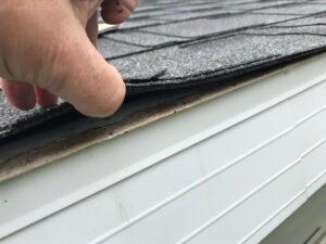 a roofing expert in austin texas inspecting the damaged roof of a home after a hailstorm