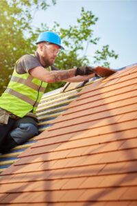 a roofing expert installing new clay tile roofing on a home