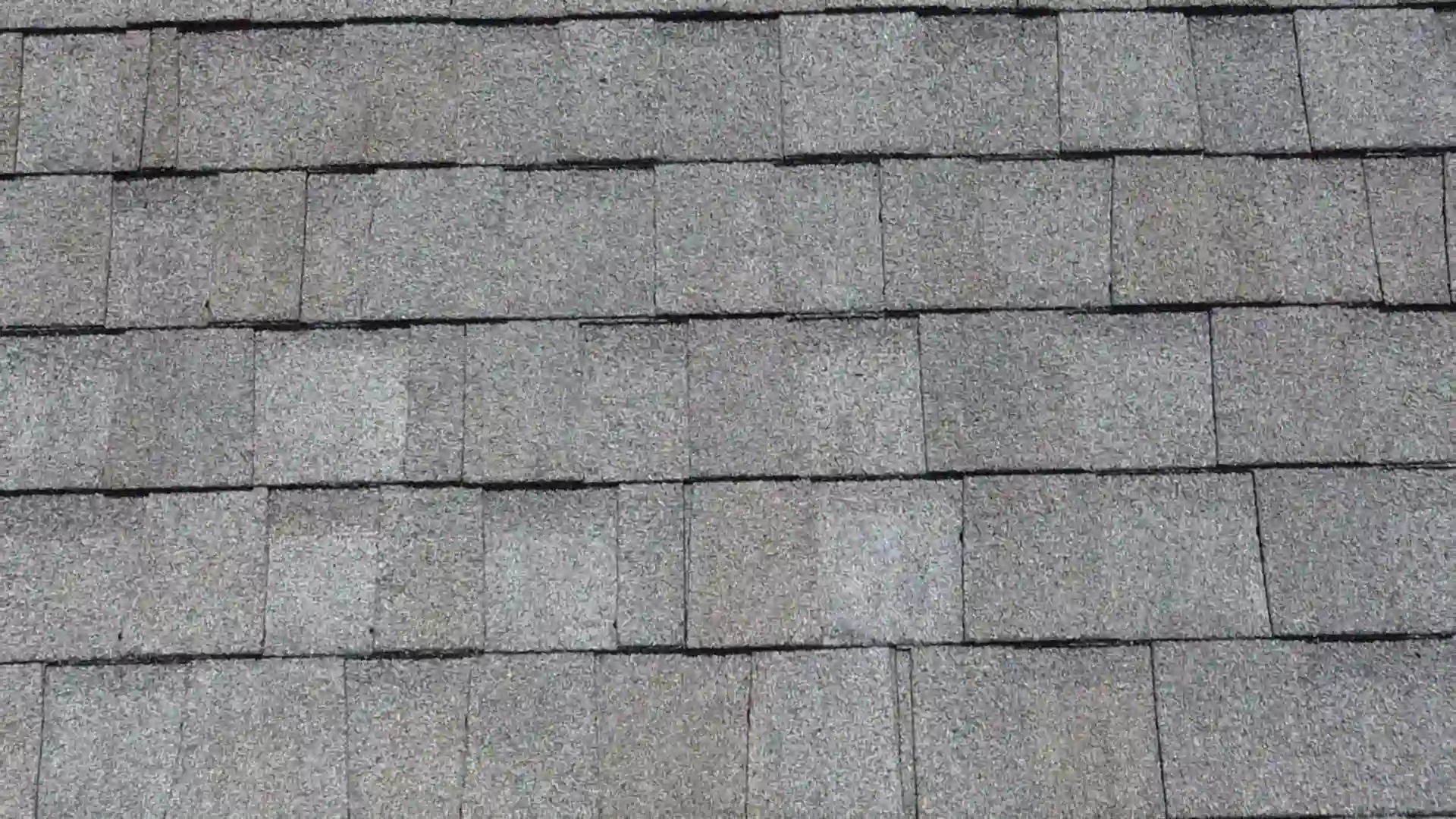 a gray roof on an austin home with granular loss damage