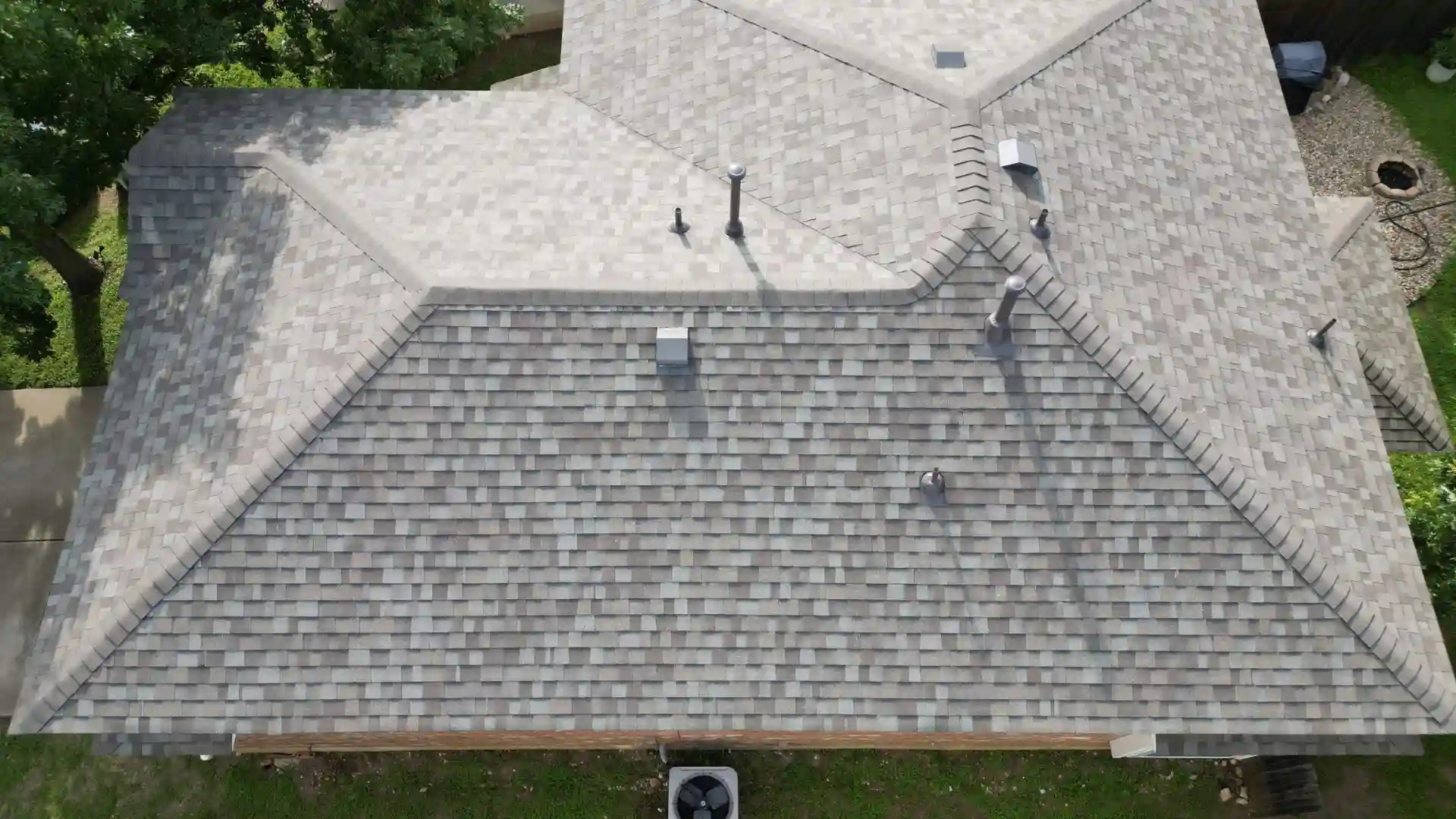 Aerial view of a house with a roof covered in gray shingles.