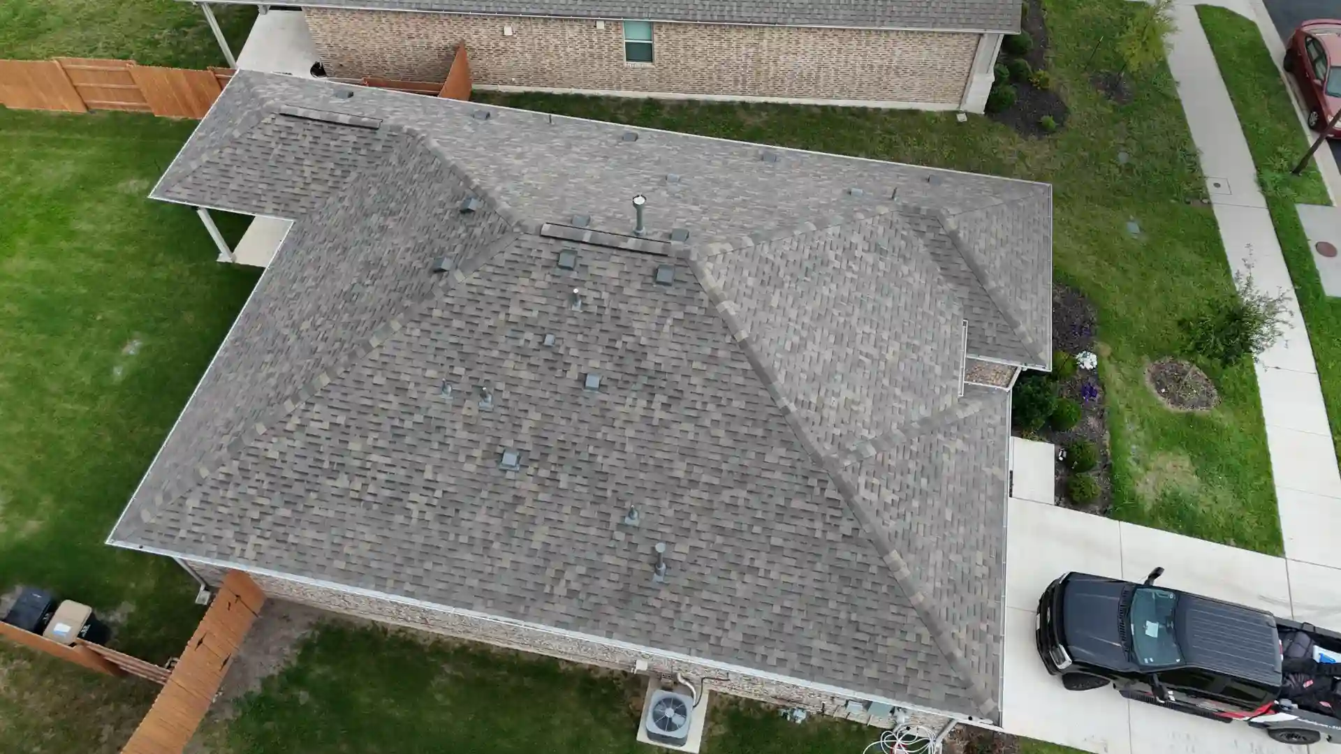 Aerial view of gray asphalt-shingle roof showing intersecting ridgelines