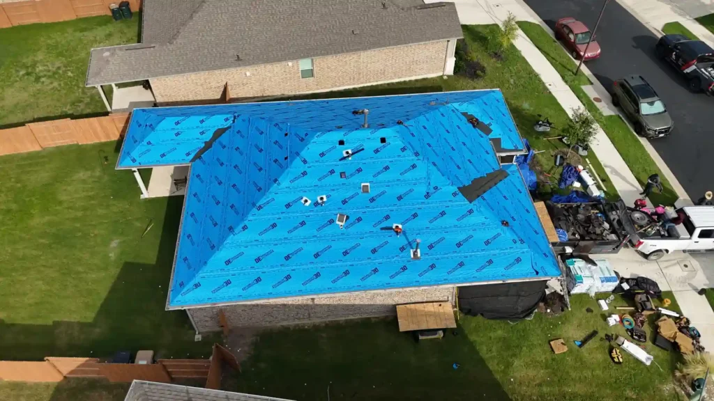 Aerial view of roof wrapped in blue synthetic underlayment