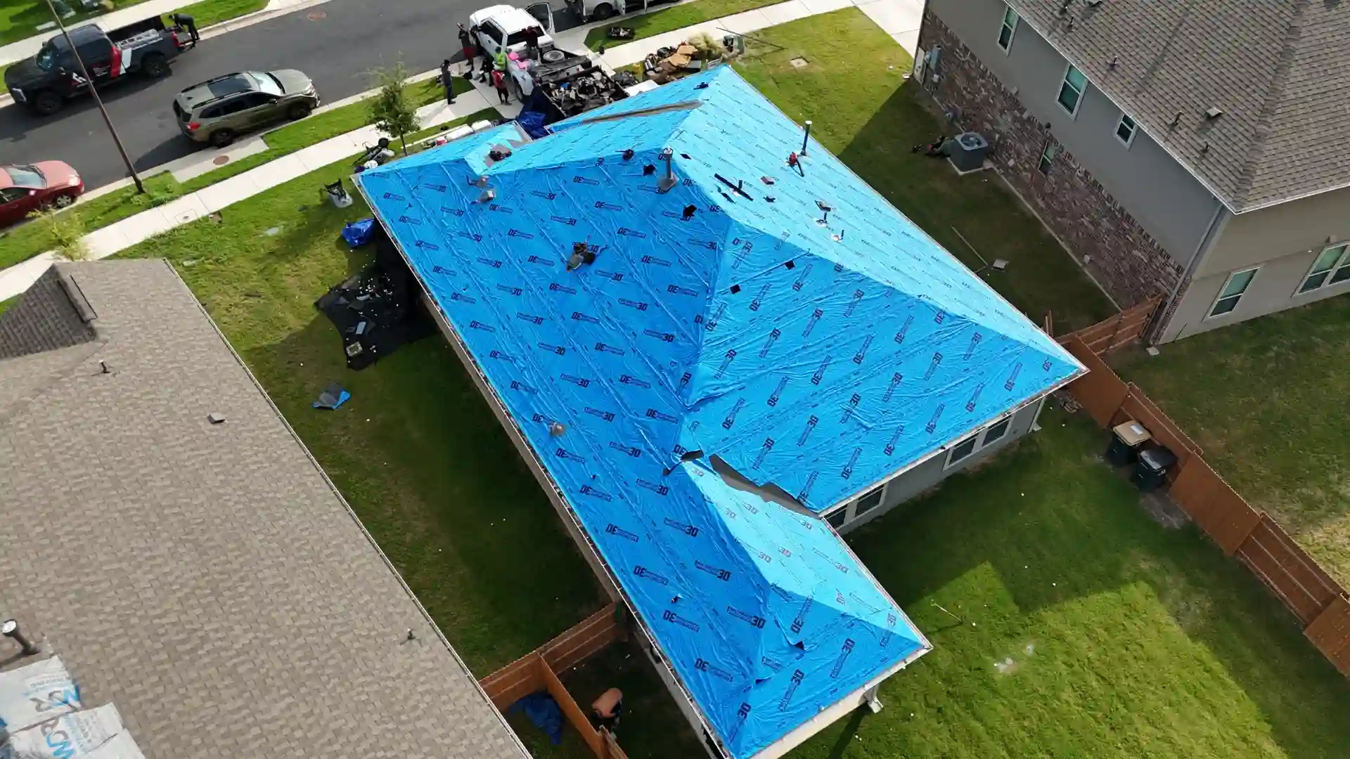 Blue synthetic underlayment covers roof during installation