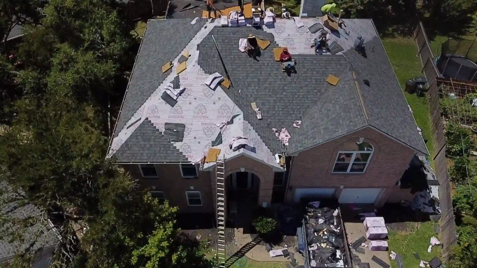 Roof under construction with workers and materials.