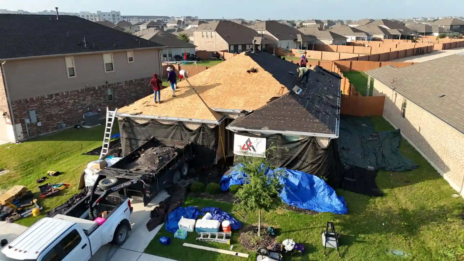 Roofers replace roof decking on suburban house during re-roofing