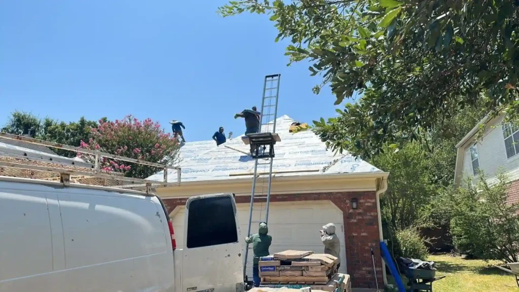 Roofers working on a house with a ladder and materials visible