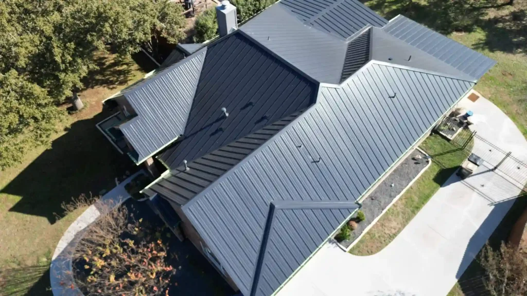 Aerial view of a modern home with a dark standing seam metal roof.