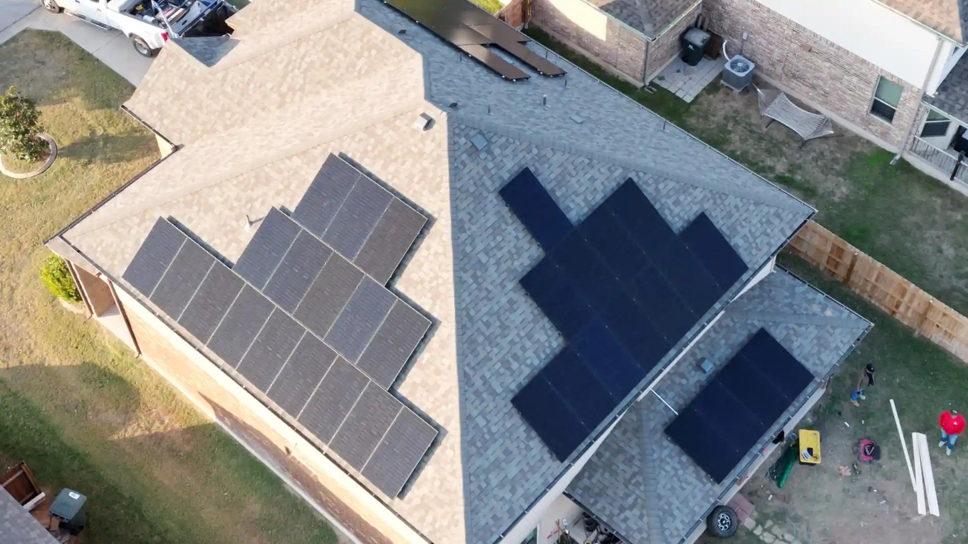 Aerial view of a house with solar panels installed on a shingle roof