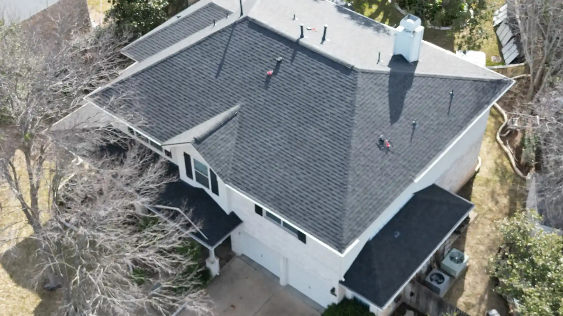 erial view of residential home with dark shingle roof