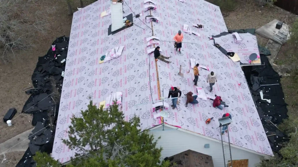 Roofing crew installing new shingles on residential home.
