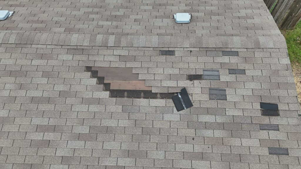Lifted and peeling 3-tab shingle tabs after wind storm damage on Austin Texas home