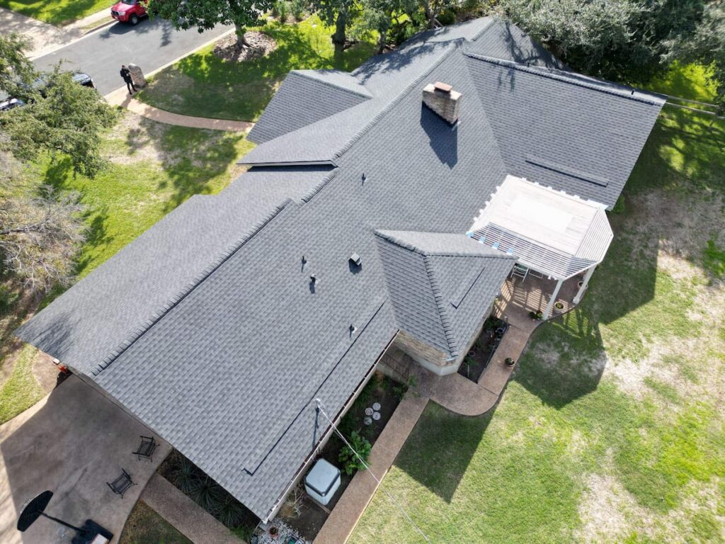 Aerial view of completed asphalt shingle roof replacement on residential home in Easton Park TX