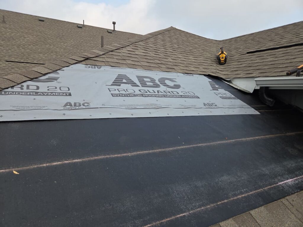 Synthetic roofing underlayment installation during roof replacement in Easton Park TX