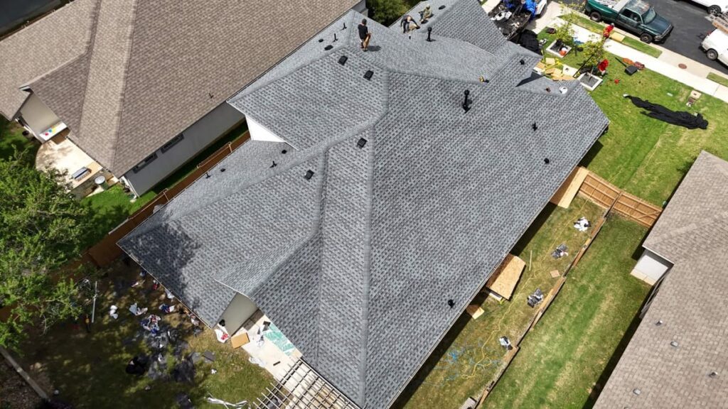 Aerial view of RoofsOnly.com crew installing new architectural shingles on Georgetown TX home during active roof replacement
