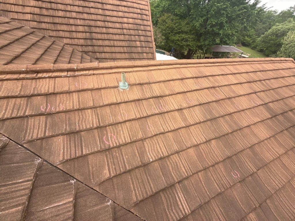 Stone-coated steel roofing shingles with chalk markings from a hail damage inspection in Austin, TX.