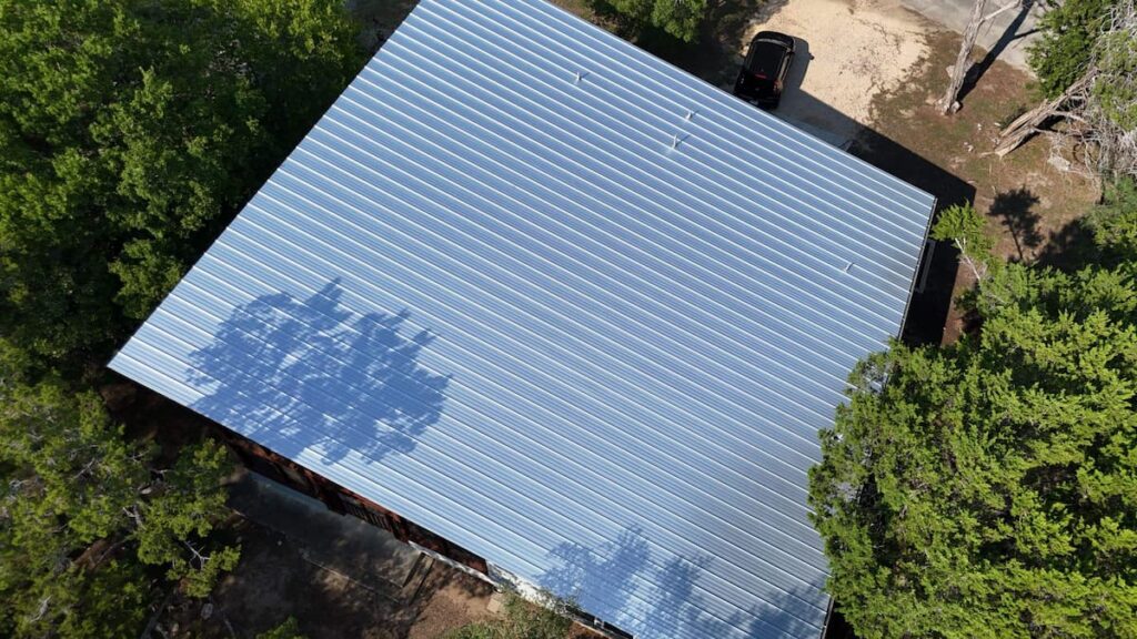 Standing seam metal roof installed on a residential home in Austin Texas reflecting heat in summer sun