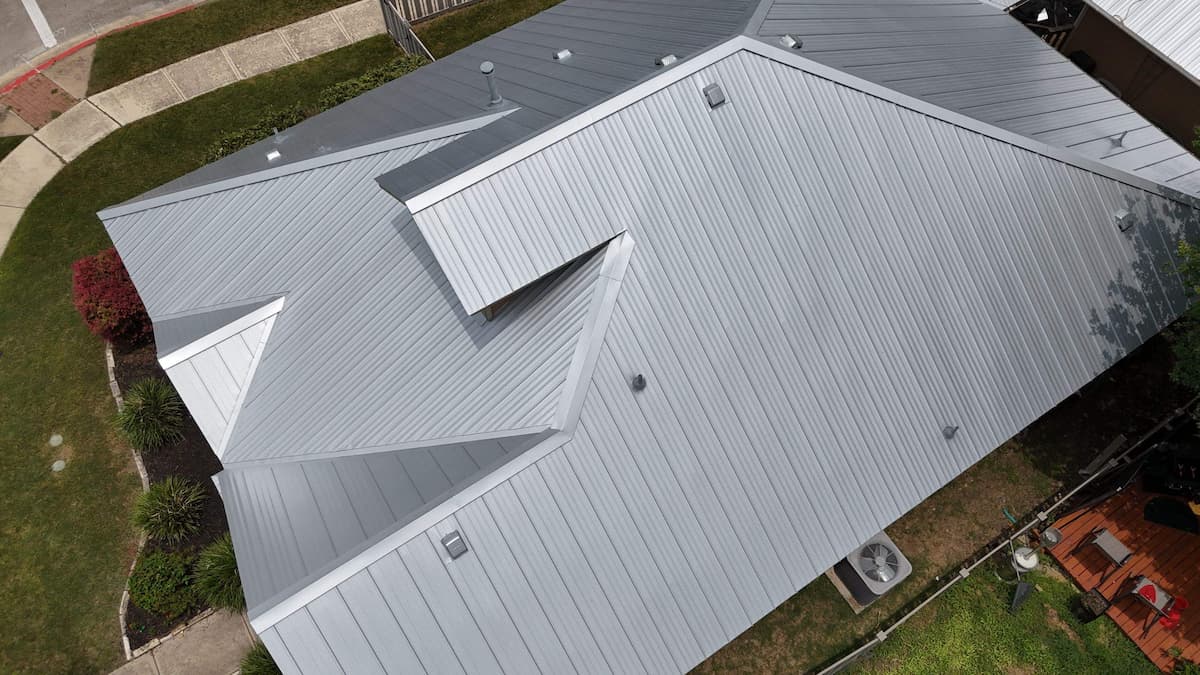 Standing seam metal roof installed on a two story residential home in Austin Texas showing clean panel lines and ridge cap