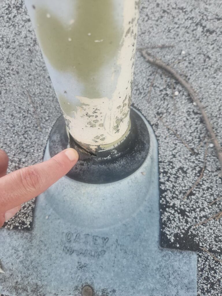Failed cracked pipe boot on an Austin Texas residential roof showing separation and UV deterioration