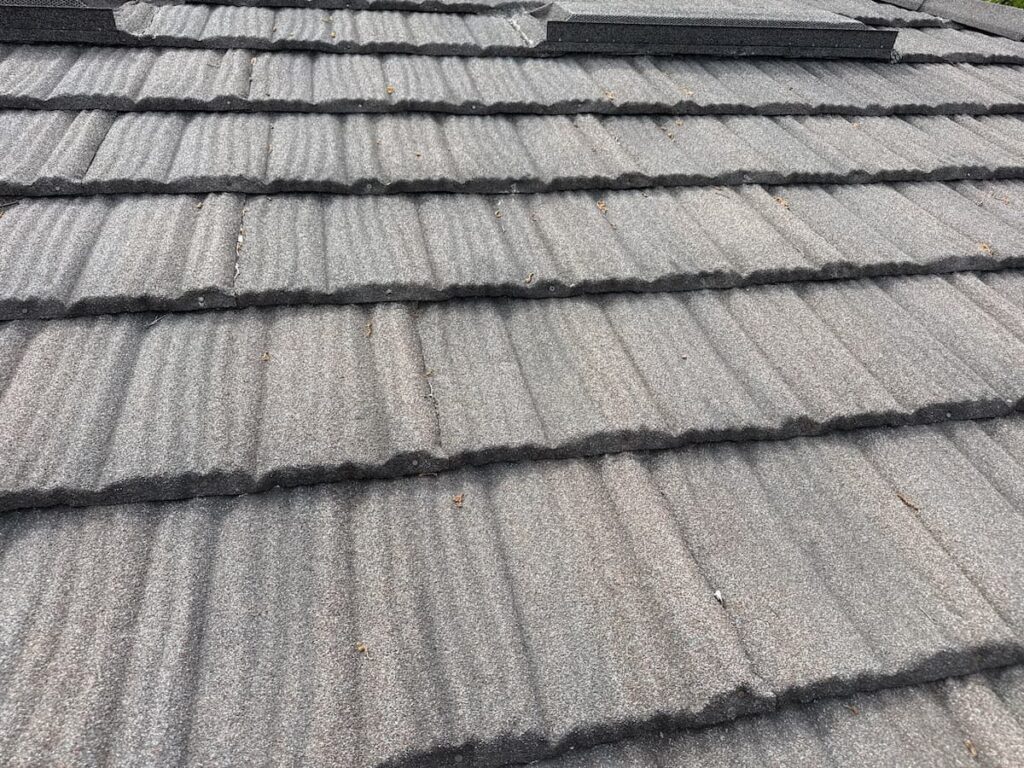 Close-up of stone-coated steel shingle profile showing granule coating and interlocking panel design