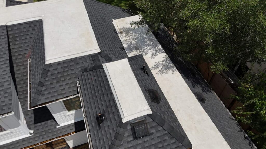 Dense tree canopy over a Central Austin home roof creating access challenges for roofing crews