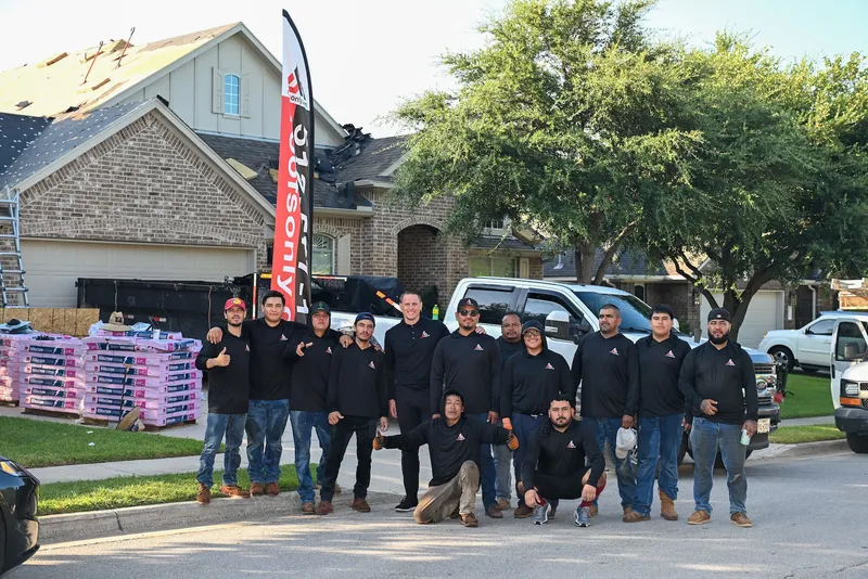 RoofsOnly.com roofing crew standing in front of a residential roofing job site in Austin, Texas