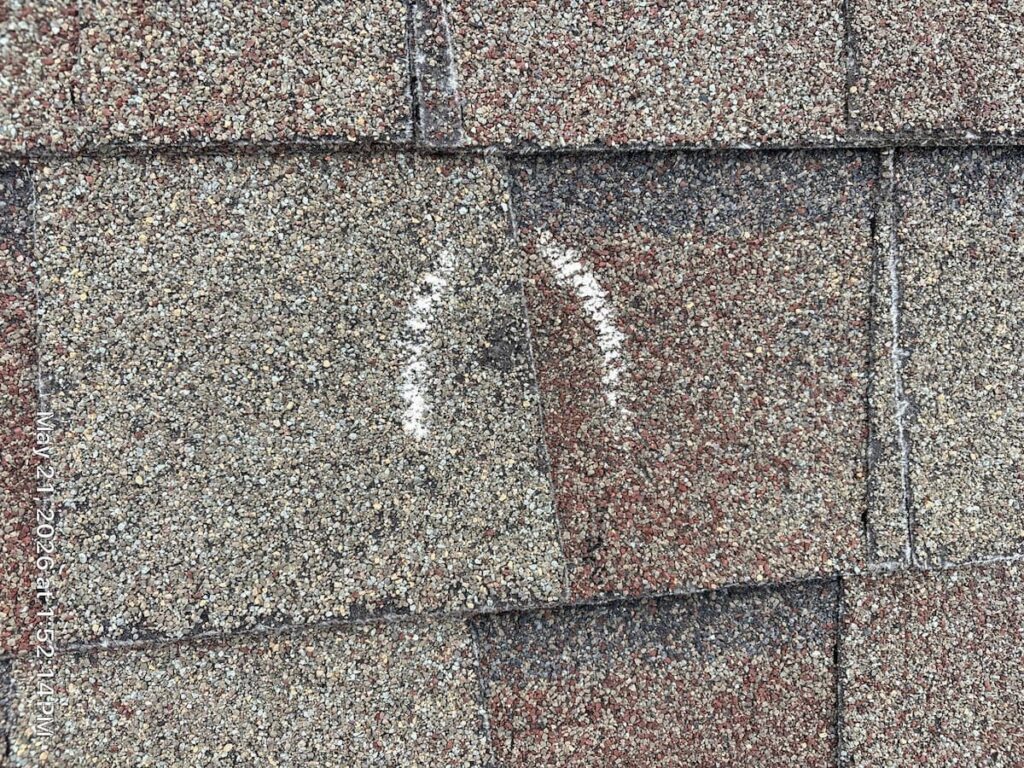 Chalk-circled hail hit on an asphalt shingle documented for a Round Rock insurance appraisal