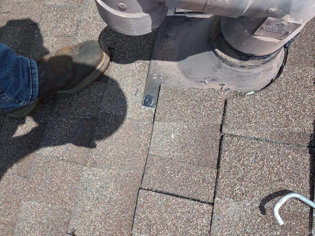 Roofer replacing underlayment and sealing penetration during a roof repair in Driftwood TX